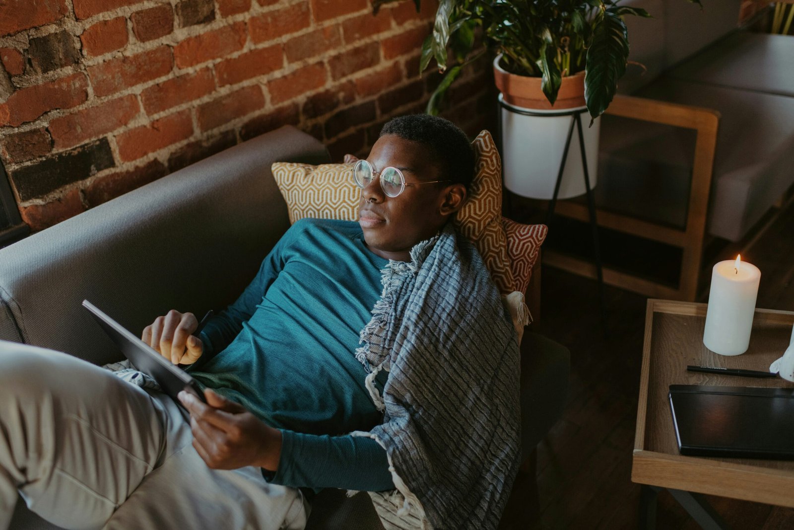 a man sitting on a couch holding a tablet